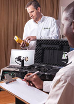 Energywise lab technicians, Daniel Zuczek and Nathi Msweli, using a power analyser and mini-goniometer to measure and record photometric and electrical performance of a light source.